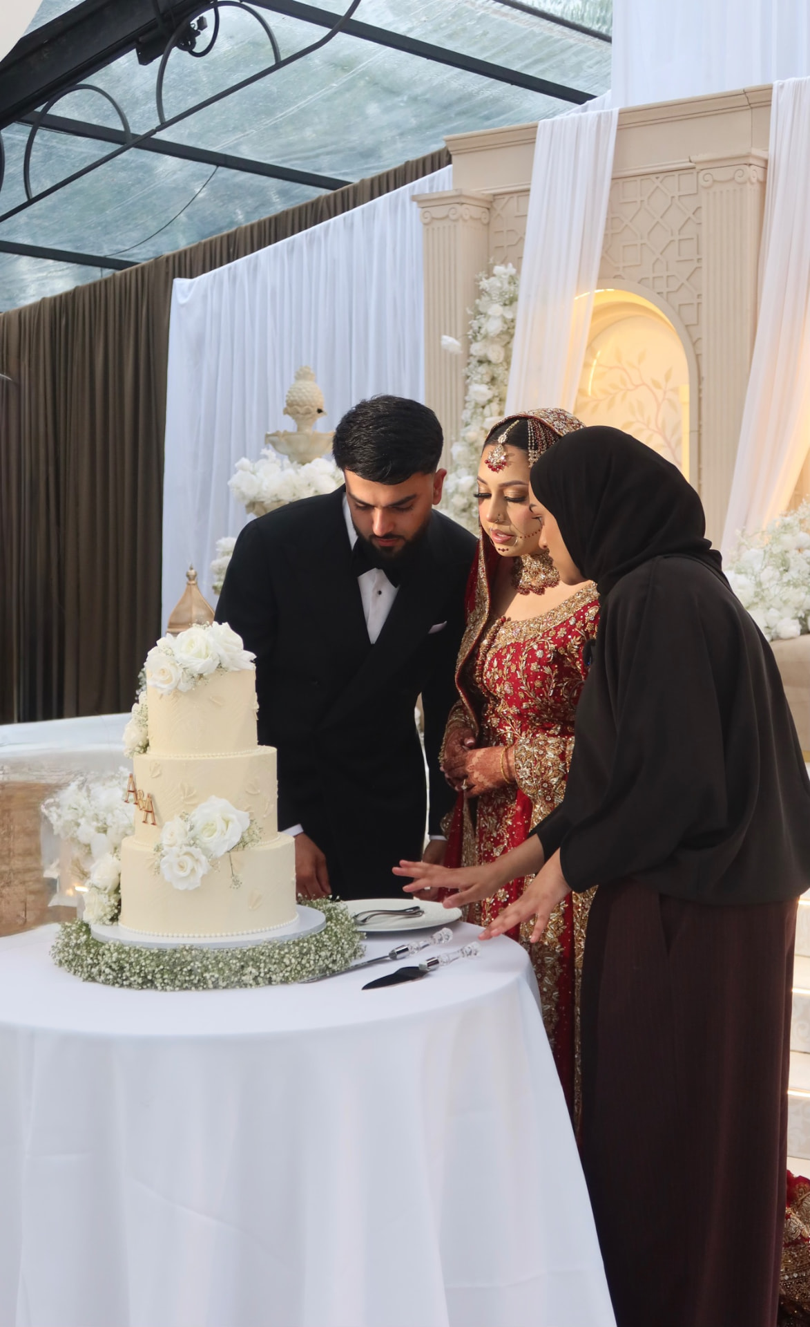 Coordinator guiding the couple through the cake cutting in a glass marquee