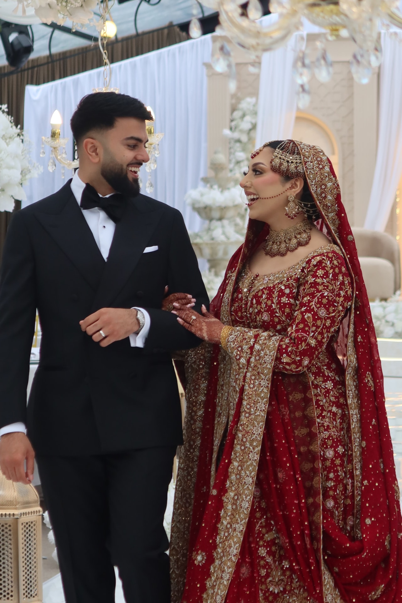 Bride and groom laughing together as they walk through the ceremony room